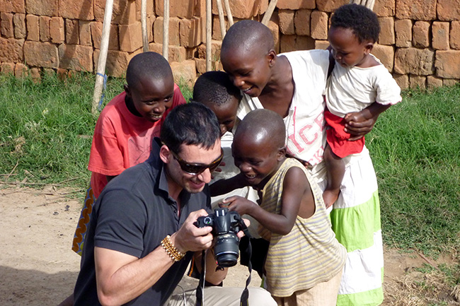 Uganda Safari guest shows his photographs to local children