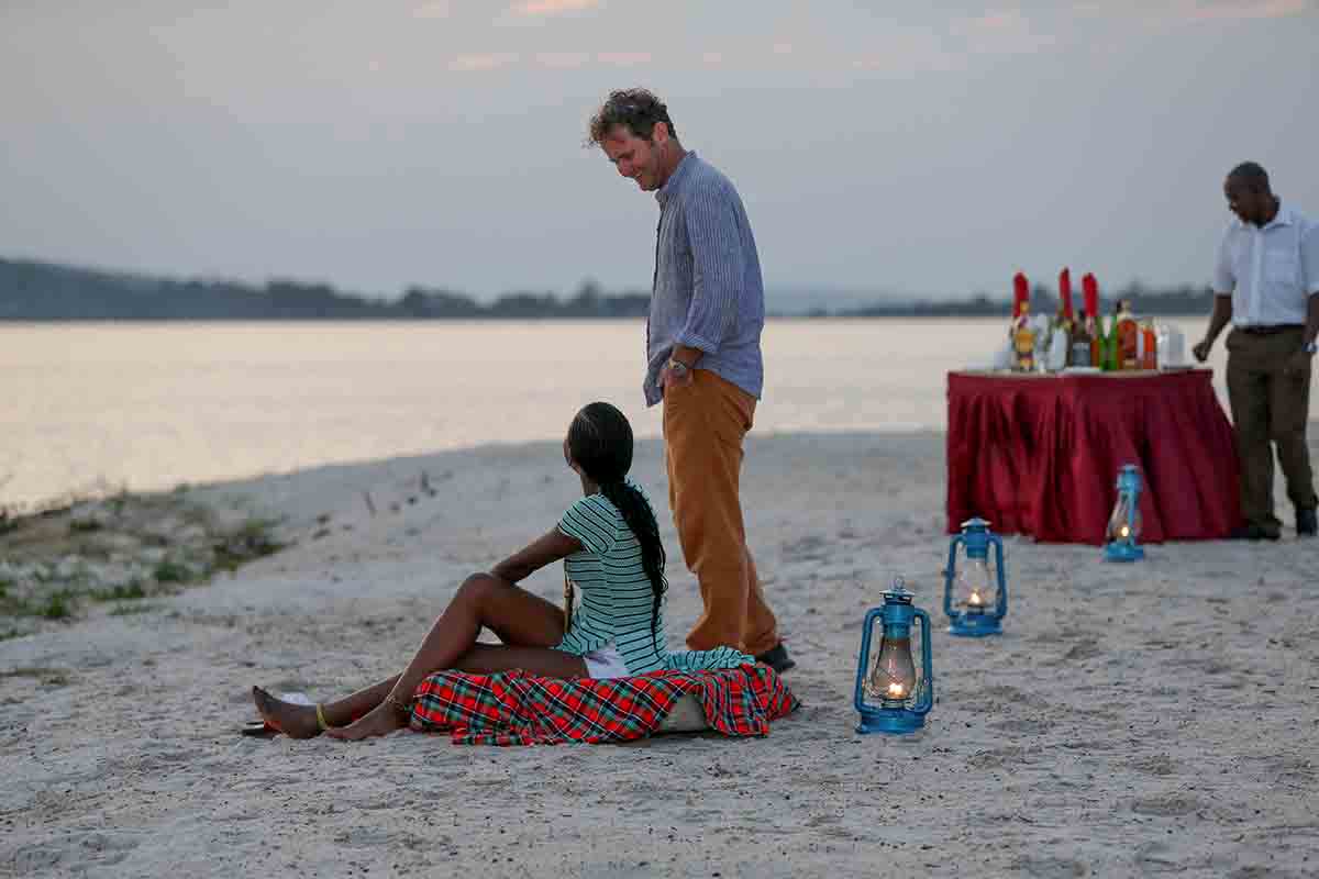 Couple relax on beach at the Victoria Forest resort in Uganda