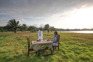 Chef prepares table for some outside dining on the shores of Lutoboka Bay